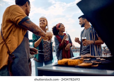 Group of friends having fun and toasting with drinks while making barbecue outdoors.  - Powered by Shutterstock