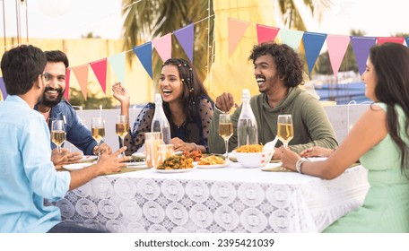 Group of Friends having fun together during evening dinner party on balcony - concept of new year or birthday celebration, friendship and festive gathering - Powered by Shutterstock