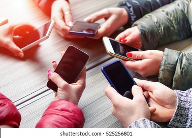 Group of friends having fun together with smartphones - Closeup of hands social networking with mobile smart phone online - Technology and phone addiction concept -Soft focus on right bottom hand