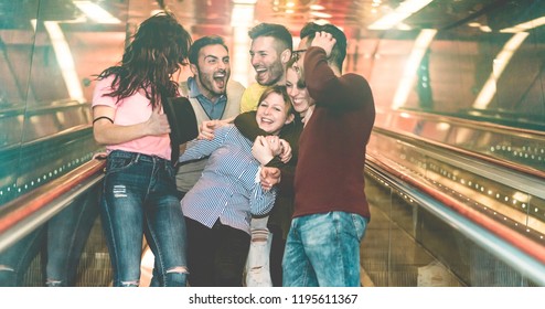 Group of friends having fun in underground metropolitan station escalator - Young people hanging out ready for party night  - Friendship and youth concept - Focus on center girl face