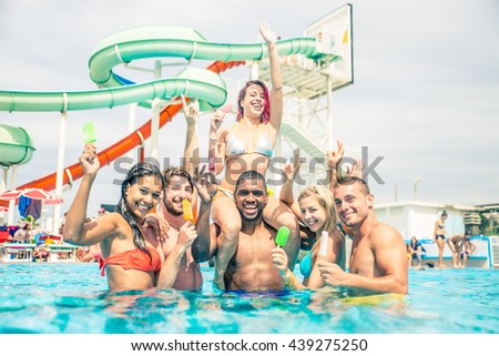 Group of friends having fun in a waterpark - Young people enjoy summer holiday