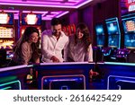A group of friends having fun while playing games at a neon-lit casino. The vibrant atmosphere enhances the entertaining experience as they engage in friendly gaming activities.