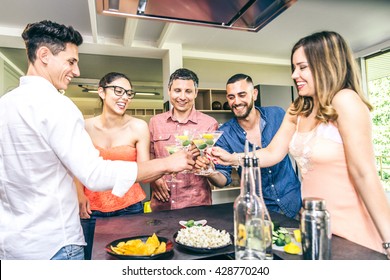 Group Of Friends Having Party At Home And Toasting Cocktail Glasses