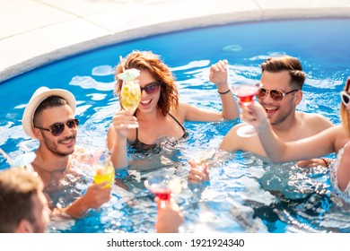 Group Of Friends Having Party In Pool, Drinking Cocktail And Enjoying Together.