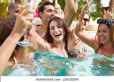 Group Of Friends Having Party In Pool Drinking Champagne