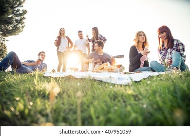 Group of friends having pic-nic in a park on a sunny day - People hanging out, having fun while grilling and relaxing - Powered by Shutterstock