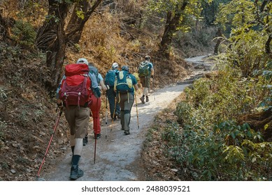 Group friends hiking with backpacks to along mountain path through beautiful forest during trek in the Himalayas, Nepal. 
Beautiful forest trekking and activity in outdoors. - Powered by Shutterstock