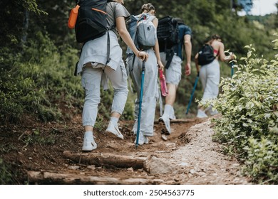 Group of friends hiking on a forest trail, enjoying outdoor adventure and bonding. They are equipped with backpacks and walking sticks. - Powered by Shutterstock