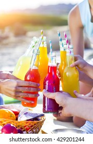 Group Of Friends Holding Drinks At The Summer Picnic. Close Up