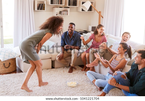 Group Of Friends At Home Having Fun Playing\
Charades Together