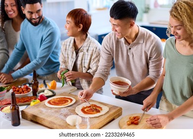 Group Of Friends At Home In Kitchen With Making Pizzas For Party Together - Powered by Shutterstock