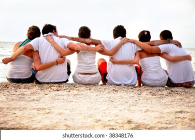 Group Of Friends Hugging At The Beach