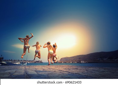 Group Of Friends Jumping To The Sea From The Pier, Happy Beach Holidays, Crete, Greece