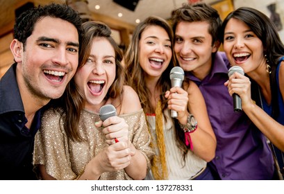 Group of friends karaoke singing at the bar