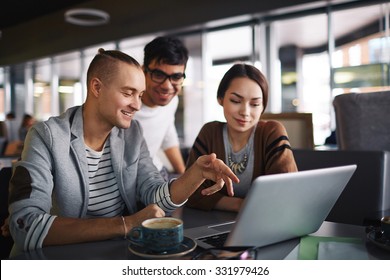 Group Of Friends With Laptop Spending Leisure In Cafe