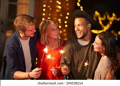 Group Of Friends Lighting Sparklers At Outdoor Party