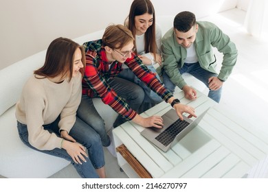 Group Of Friends Looking At Something On A Laptop Computer