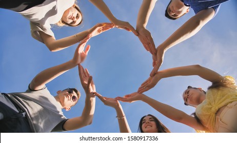 A group of friends makes a circle from the palms of their hands. - Shutterstock ID 1580917336