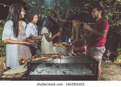 Group Of Friends Making Barbecue In The Backyard At Dinner Time. Spending Quality Time , And Eating Healthy Food Outdoor. Lifestyle Concept In The Evening