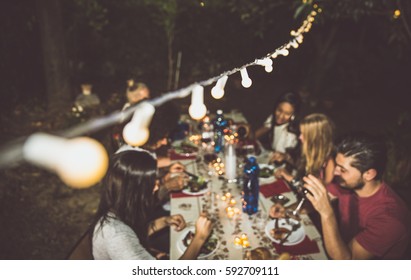 Group Of Friends Making Barbecue In The Backyard At Dinner Time