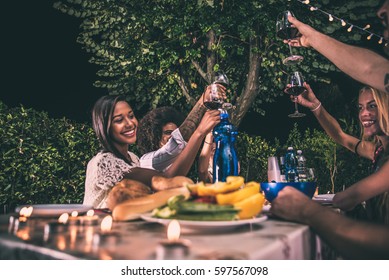 Group Of Friends Making Barbecue In The Backyard At Dinner Time