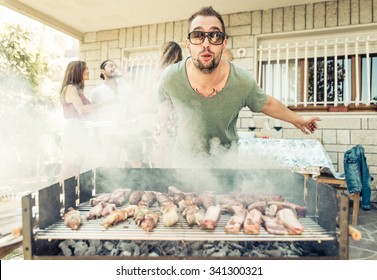 Group Of Friends Making Barbecue Outside In The Garden