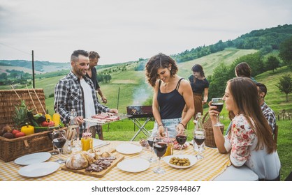 Group of friends making barbeque  in a countryside house. Happy people spending the weekend in a farmhouse eating good healthy food and having fun in the nature - Powered by Shutterstock