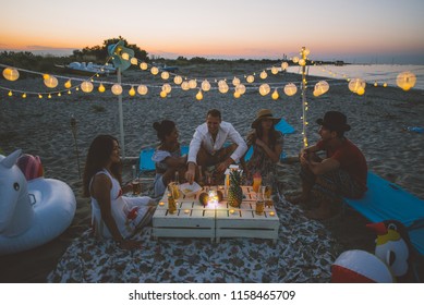 Group of friends making party on the beach at sunset time - Powered by Shutterstock