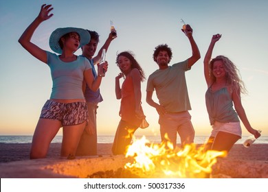 Group Of Friends Making Party On The Beach With Fire And Music