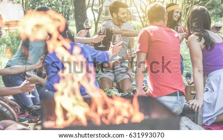 Group of friends making picnic with barbecue on city park outdoor - Young people eating bbq meal and drinking wine at dinner in backyard - Focus on behind right guys - Youth concept - Vintage filter