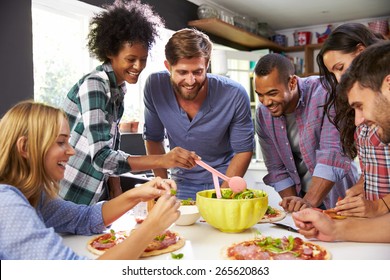 Group Of Friends Making Pizza In Kitchen Together - Powered by Shutterstock