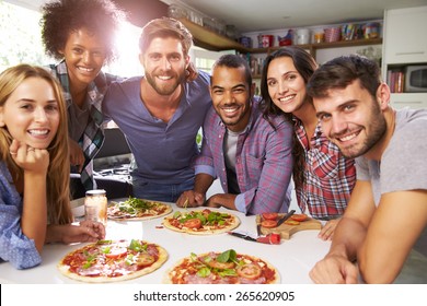 Group Of Friends Making Pizza In Kitchen Together - Powered by Shutterstock