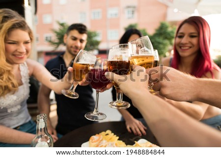 Group of friends making a toast with alcoholic drinks