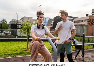 Group Of Friends Man And Women Male And Young Adult People Training At Outdoor Open Gym In Park In Front Of Modern Building Real People Sport And Recreation Exercise Healthy Lifestyle Concept