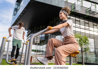 Group Of Friends Man And Women Male And Young Adult People Training At Outdoor Open Gym In Park In Front Of Modern Building Real People Sport And Recreation Exercise Healthy Lifestyle Concept