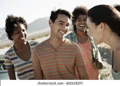 A group of friends, men and women, on the open road, walking and talking - Shutterstock ID 602618297