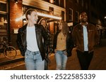 Group of friends, men and women, walking at night. Friends smiling, enjoying nightlife. Diverse group hanging out at city street. Friends having fun nightlife. Diverse friends go to the bar at night