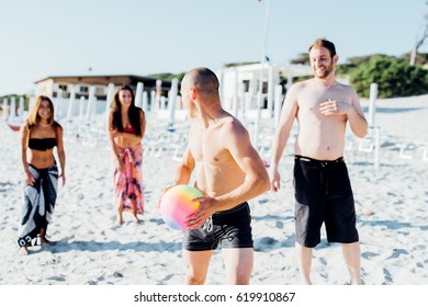 Group Of Friends Millennials Playing On The Beach With Beach Ball - Activiies, Sportive, Having Fun Concept