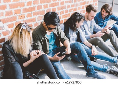 Group Of Friends Multiethnic Millennials Sitting Outdoor Using Smart Phone - Technology, Having Fun, Togetherness Concept