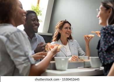 Group of friends multiracial company members having lunch during break at workplace eating pizza chatting laughing enjoy communication, team building activity and good warm relations at work concept - Powered by Shutterstock