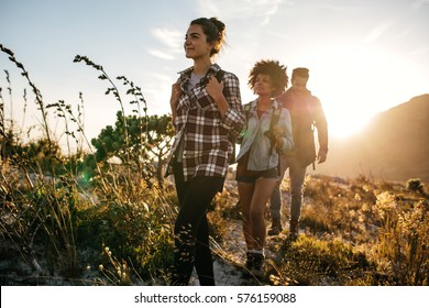 Group Of Friends On Country Walk On A Summer Day. Young People Hiking In Countryside.