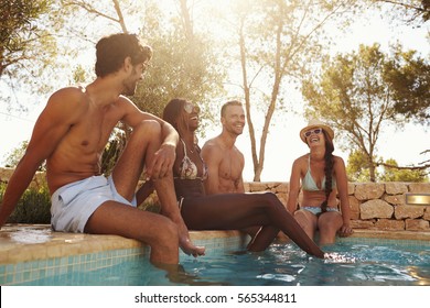 Group Of Friends On Vacation Relaxing Next To Outdoor Pool - Powered by Shutterstock