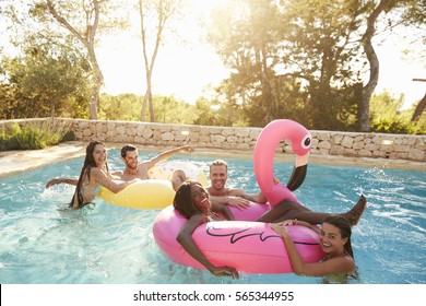 Group Of Friends On Vacation Relaxing In Outdoor Pool - Powered by Shutterstock