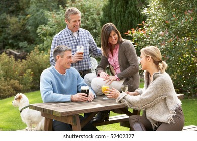 Group Of Friends Outdoors Enjoying Drink In Pub Garden