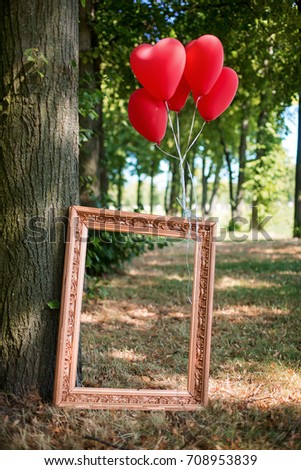 A group of friends in the park with a fun party. Rockabilly in the park.
Picture frame with a balloon stands near a tree