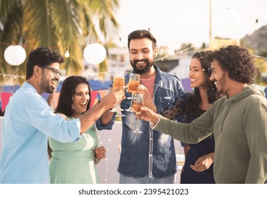 Group of friends at party champagnes glasses at party during new year evening party gathering - concept of millennial lifestyle, birthday celebration and enjoyment - Powered by Shutterstock