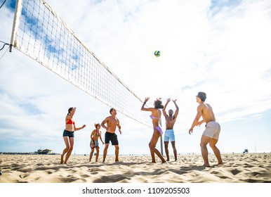 Group of friends playing beach volley - Multi-ethic group of people having fun on the beach