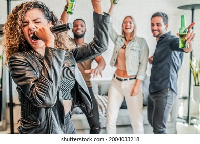 Group Of Friends Playing Karaoke At Home.