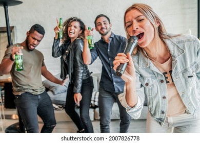 Group Of Friends Playing Karaoke At Home.