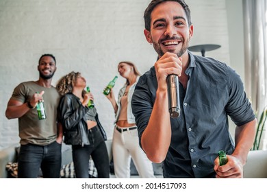 Group Of Friends Playing Karaoke At Home.